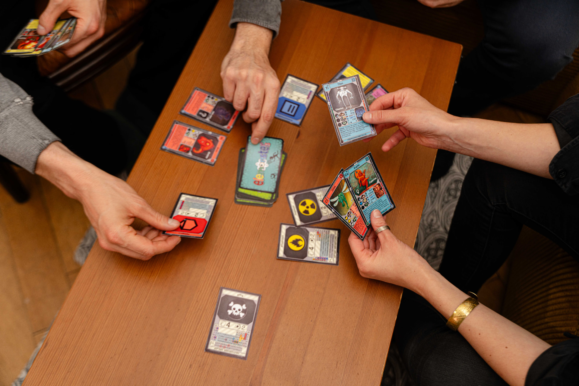Menschen spielen eine Partie Elemonsters am Tisch